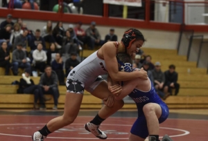 Adalia George executing a takedown on a wrestling mat